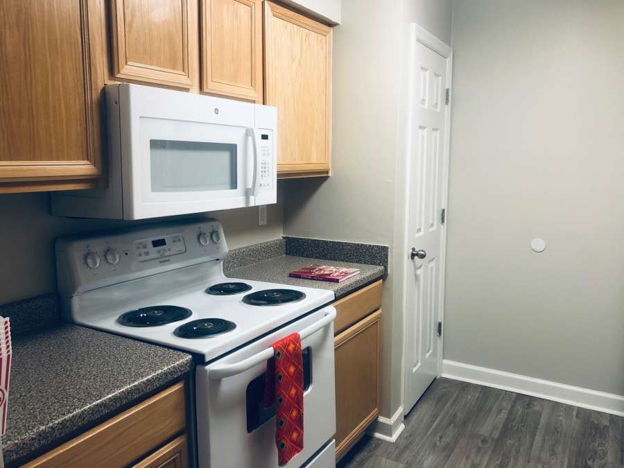 a kitchen with a white stove and wooden cabinets