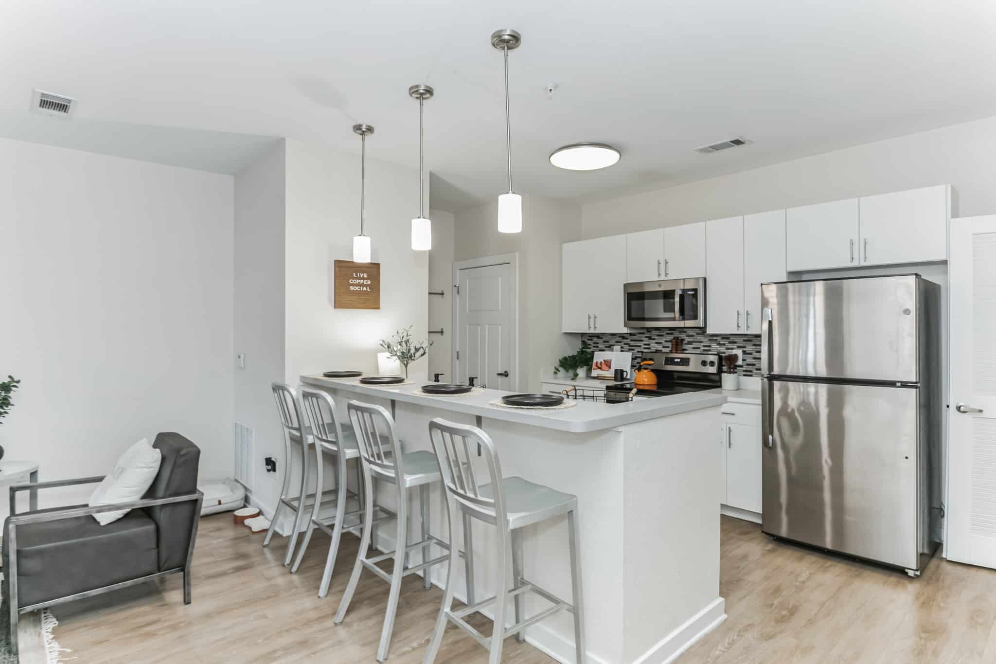 a kitchen with a bar and a refrigerator
